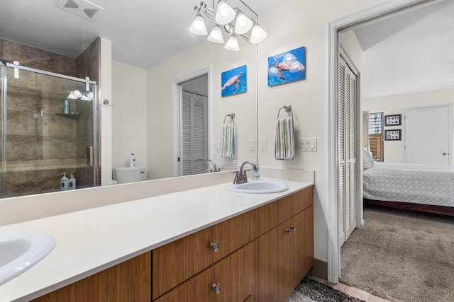 bathroom with vanity, toilet, and a shower with door