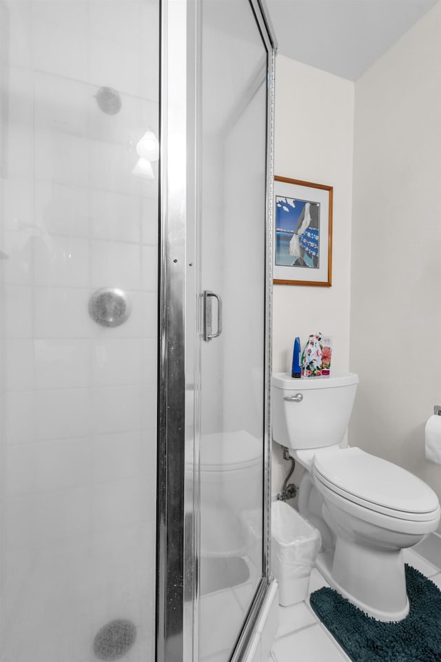 bathroom featuring tile patterned floors, an enclosed shower, and toilet