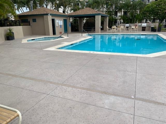 view of swimming pool featuring a gazebo, a hot tub, and a patio area