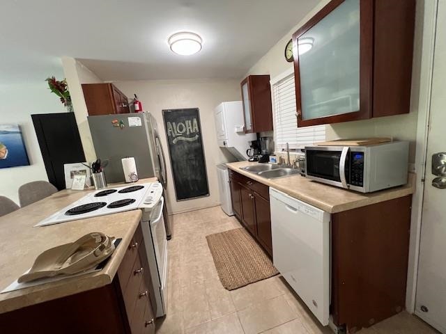 kitchen with appliances with stainless steel finishes, sink, and light tile patterned floors