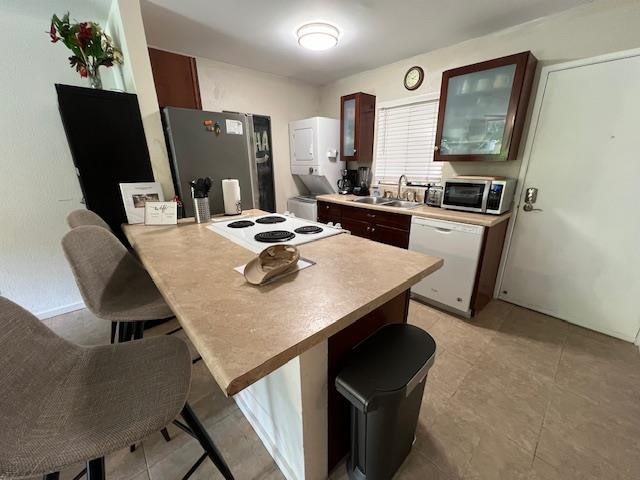 kitchen featuring appliances with stainless steel finishes, kitchen peninsula, a breakfast bar area, and sink