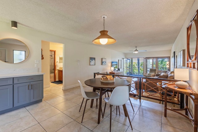 tiled dining area with a textured ceiling and ceiling fan