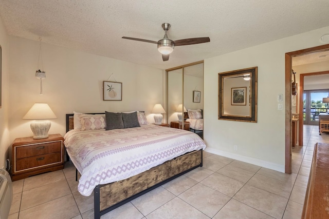 tiled bedroom featuring a textured ceiling, ceiling fan, and a closet