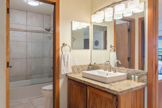 bathroom featuring enclosed tub / shower combo, vanity, tile patterned flooring, and toilet