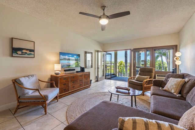 living room with a textured ceiling, light tile patterned floors, and ceiling fan