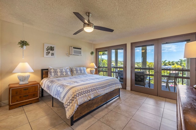 bedroom featuring light tile patterned floors, a wall mounted air conditioner, access to outside, a textured ceiling, and french doors