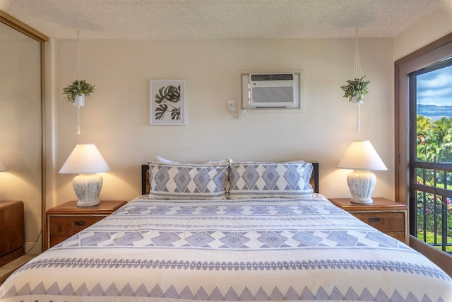 bedroom with a wall mounted AC and a textured ceiling