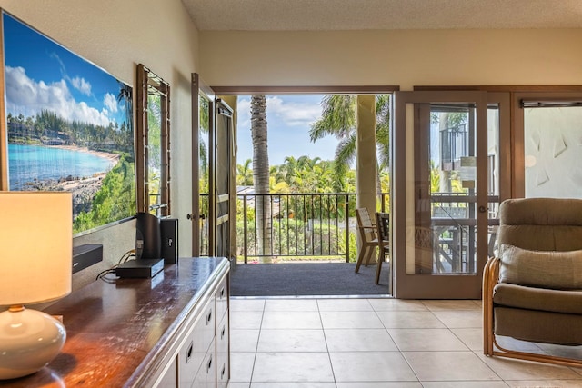 entryway with light tile patterned floors, french doors, and a textured ceiling