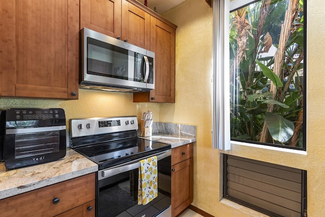 kitchen featuring light stone countertops and stainless steel appliances