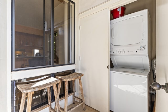 clothes washing area with stacked washer / drying machine