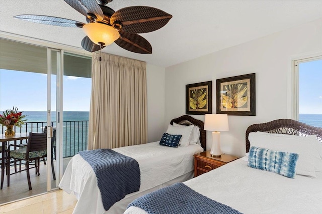 bedroom with access to outside, a water view, ceiling fan, and light tile patterned floors