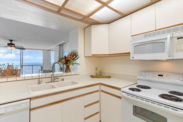 kitchen featuring white cabinets, a ceiling fan, a sink, and white appliances