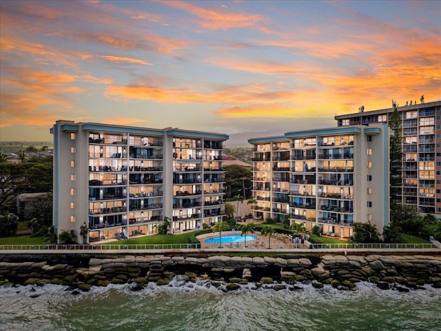 property at dusk featuring a water view