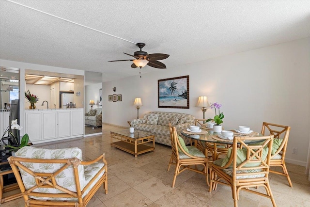 dining space with a textured ceiling and ceiling fan