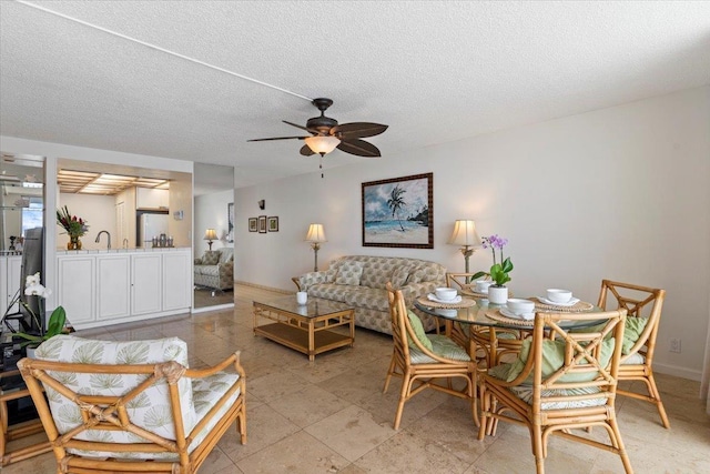 interior space with a textured ceiling, baseboards, and a ceiling fan