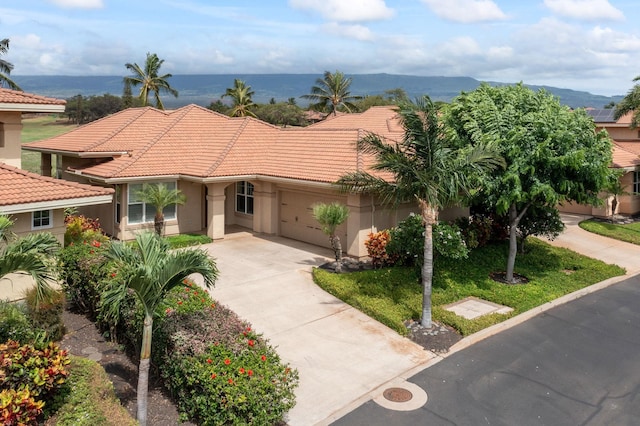 2563 Umeke Cir Unit 64, Kihei, HI 96753 - mediterranean / spanish home featuring driveway, stucco siding, a tile roof, and a garage