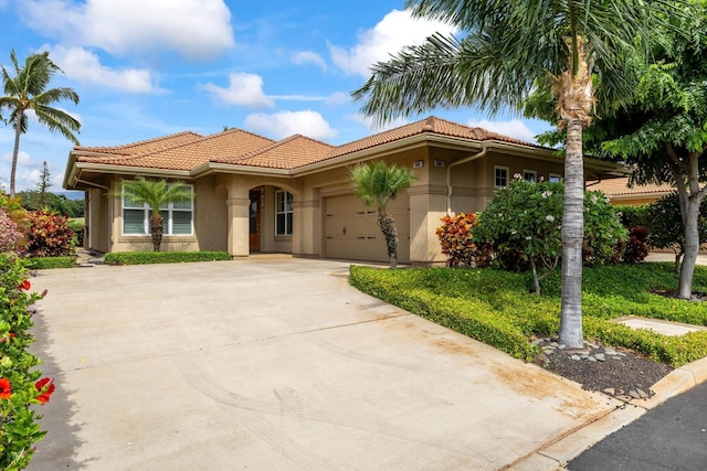 2563 Umeke Cir Unit 64, Kihei, HI 96753 - mediterranean / spanish house featuring driveway, an attached garage, a tiled roof, and stucco siding