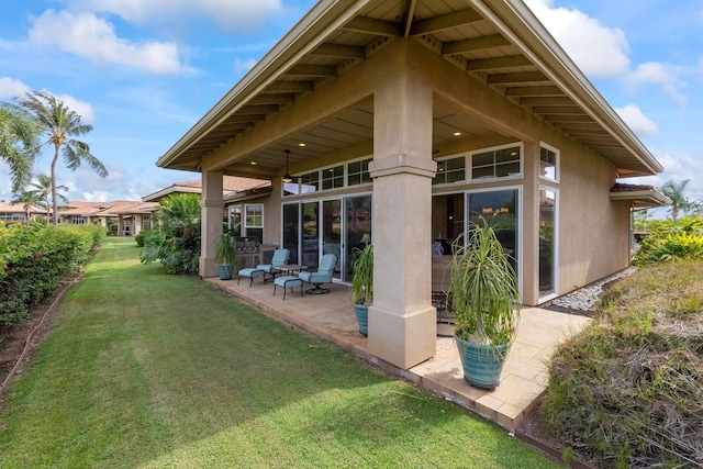 2563 Umeke Cir Unit 64, Kihei, HI 96753 - back of house featuring a patio, a yard, and stucco siding