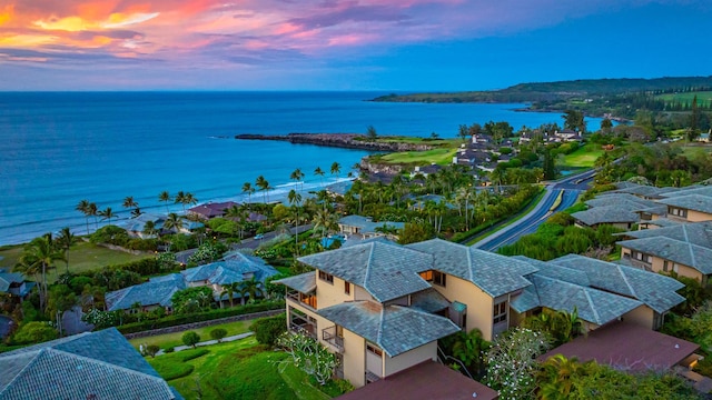 aerial view at dusk featuring a water view and a residential view