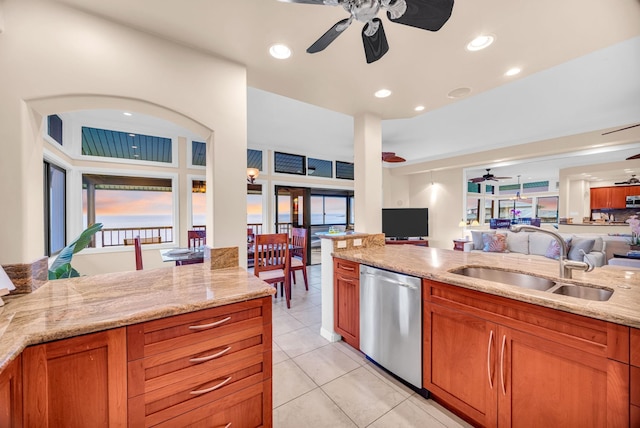 kitchen with stainless steel dishwasher, a ceiling fan, open floor plan, and a sink