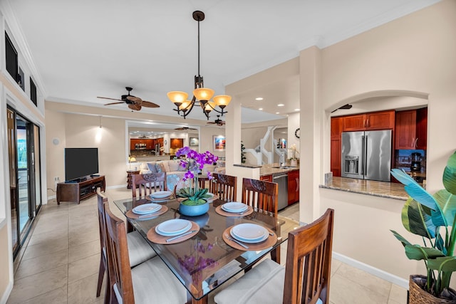 dining room with baseboards, ornamental molding, ceiling fan with notable chandelier, and light tile patterned floors