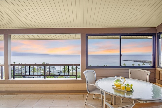 sunroom with a water view and tile patterned flooring
