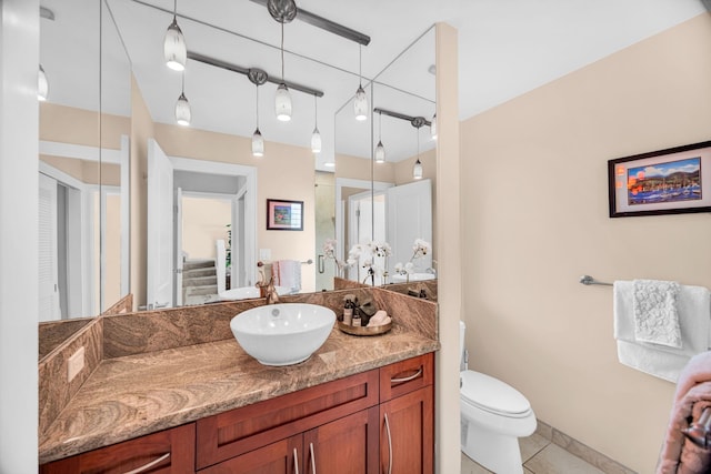 bathroom featuring toilet, a shower with door, tile patterned flooring, and vanity