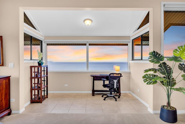 home office featuring baseboards, a water view, and tile patterned flooring