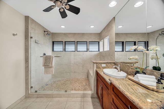 full bathroom featuring vanity, a ceiling fan, tile patterned floors, and tiled shower