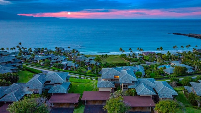 aerial view at dusk with a water view and a residential view