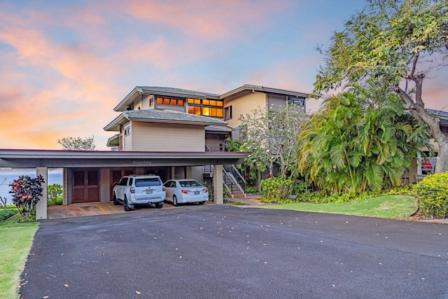 view of front of house with stairway, driveway, and a carport