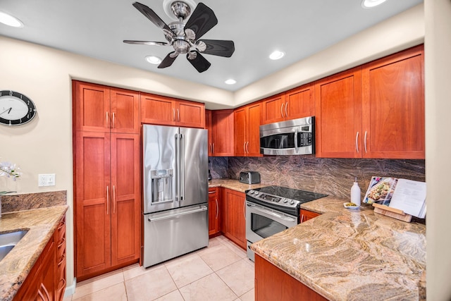 kitchen featuring backsplash, appliances with stainless steel finishes, brown cabinetry, and light stone counters