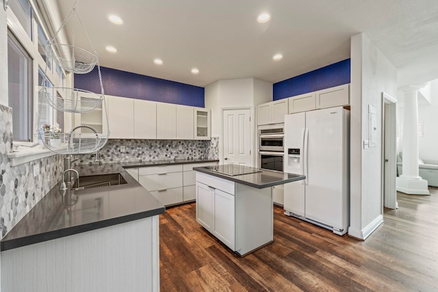 kitchen featuring dark hardwood / wood-style flooring, white cabinetry, a center island, and white refrigerator with ice dispenser