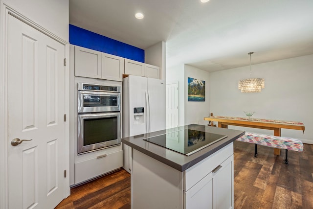 kitchen with white cabinetry, stainless steel double oven, dark hardwood / wood-style floors, decorative light fixtures, and black electric cooktop