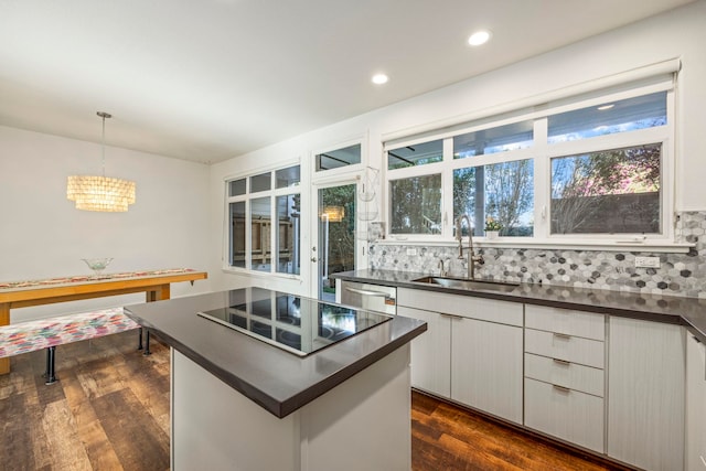 kitchen with pendant lighting, white cabinets, sink, decorative backsplash, and dark hardwood / wood-style flooring