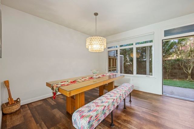 dining space with dark hardwood / wood-style flooring and a notable chandelier