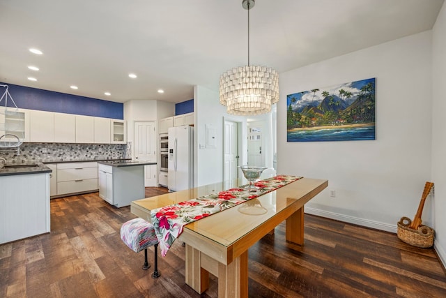 dining room featuring dark hardwood / wood-style flooring and an inviting chandelier