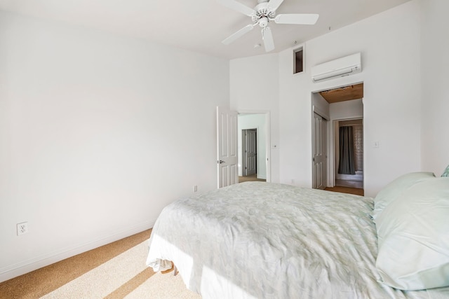 bedroom with ceiling fan, an AC wall unit, and carpet floors