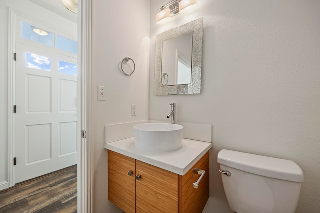 bathroom with vanity, toilet, and wood-type flooring