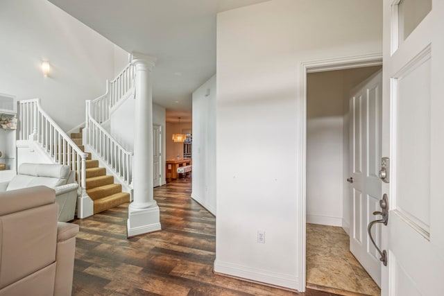 entryway featuring dark hardwood / wood-style flooring and decorative columns