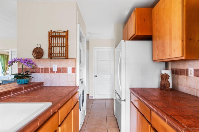 50 Kepuhi Pl Unit 128, Maunaloa, HI 96770 - kitchen featuring tile counters, light tile patterned floors, stacked washer / dryer, and tasteful backsplash