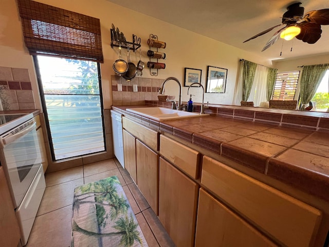 kitchen featuring tile counters, a wealth of natural light, white appliances, and sink