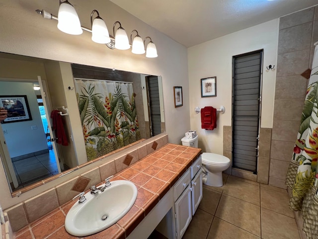 bathroom with walk in shower, vanity, tile patterned flooring, and toilet