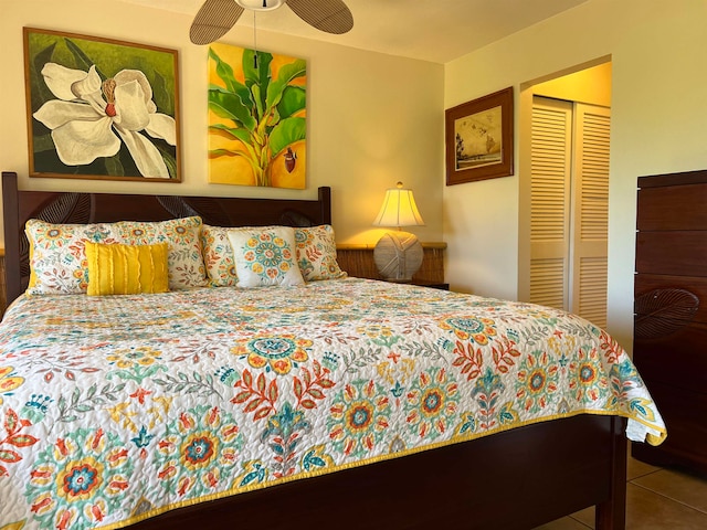 tiled bedroom featuring ceiling fan and a closet