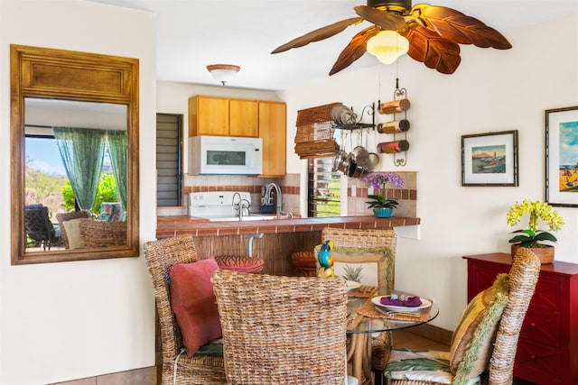50 Kepuhi Pl Unit 128, Maunaloa, HI 96770 - kitchen with stove, a ceiling fan, baseboards, decorative backsplash, and white microwave