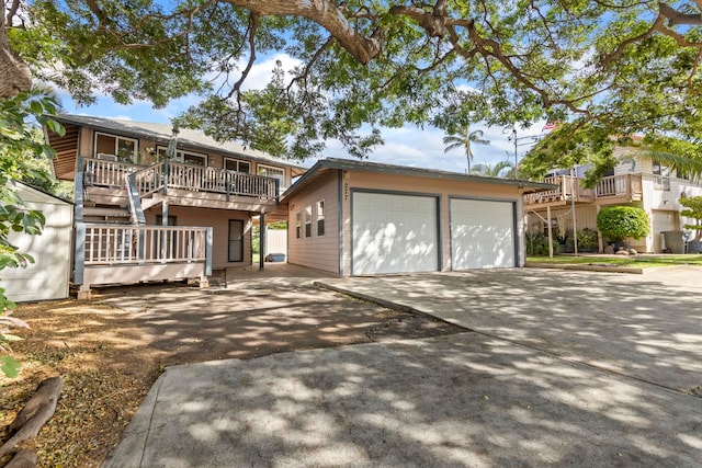 view of front of home with a garage, a deck, and an outdoor structure