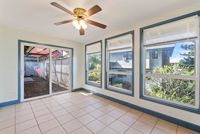 empty room with ceiling fan and light tile patterned flooring