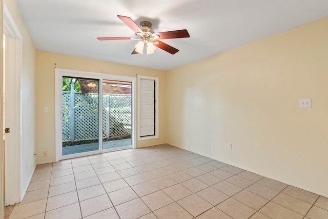 tiled spare room with ceiling fan