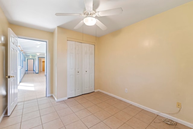 unfurnished bedroom with a closet, light tile patterned floors, and ceiling fan