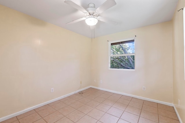 tiled spare room with ceiling fan